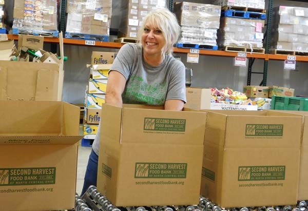 Volunteer packing a box of food